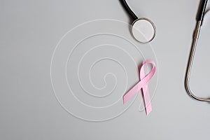 Breast Cancer Awareness, Pink Ribbon with Stethoscope on grey background for supporting people living and illness. Woman