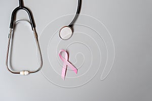 Breast Cancer Awareness, Pink Ribbon with Stethoscope on grey background for supporting people living and illness. Woman