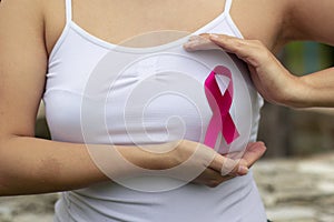 Breast cancer awareness. Woman hand holding pink ribbon