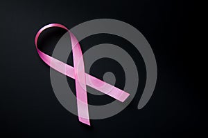 Breast Cancer concept. Pink ribbon symbol of breast cancer on black background.