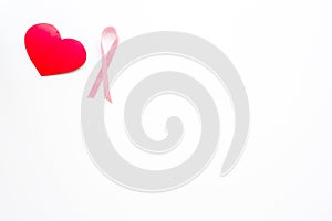 Breast cancer. Mammalogy concept. Symbolic pink ribbon near heart sign on white background top view copy space