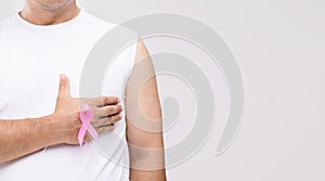 Breast cancer in men concept : Portrait Asian man and pink ribbon the symbol of breast cancer campaign. Studio shot isolated on