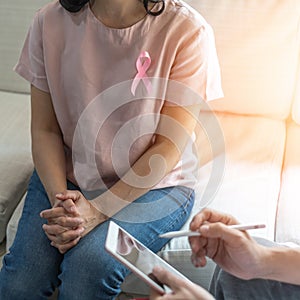 Breast cancer pink awareness ribbon on woman patient consulting with doctor who diagnostic examining on obstetric - gynaecological