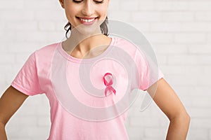Unrecognizable Girl With Cancer Ribbon On T-Shirt Standing, White Background