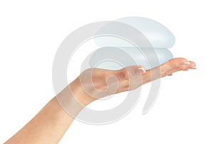 Breast implants in hand  on white background with clipping path.