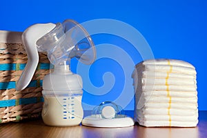 Breast pump stands among nipples and diapers