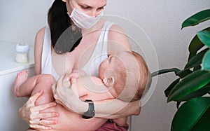 Breastfeeding baby eating milk from mother`s breast and bottle. Concept - breastfeeding and motherhood