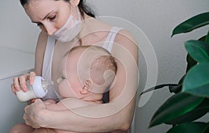 Breastfeeding baby eating milk from mothers breast and bottle. Concept - breastfeeding and motherhood