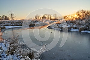 Breath of winter, first ice on the lake, dawn on a frosty morning with frost on the grass, close-up of frost, patterns on the