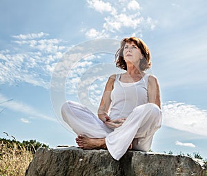 Breathing outdoors for beautiful middle aged yoga woman