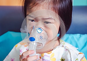 Breathing through a steam nebulizer. Illness girl admitted in hospital. photo