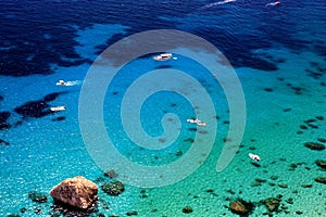 Breathtakig view from above on the sea with transparent water and white boats.