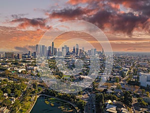 A breathtaking aerial shot of downtown Los Angeles with skyscrapers lush green trees, small buildings and homes