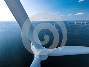 A breathtaking aerial view of a wind farm in the ocean, showcasing rows of towering windmill turbines generating