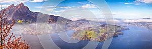 Breathtaking autumn view of Stansstad city and Lucerne lake with mountaines and fog