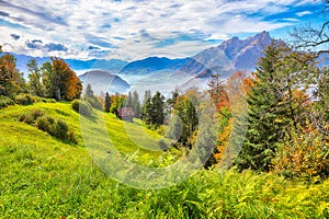 Breathtaking autumn view on suburb of Stansstad city and Lucerne lake with mountaines and fog