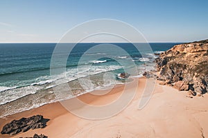 Breathtaking cliffs surround the sandy beach of Praia da Angra da Cerva on the Atlantic coast near Vila Nova de Milfontes, Odemira photo