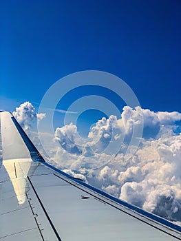 Breathtaking cloudy sky and wing view from the window of the internal cabin of the airplane