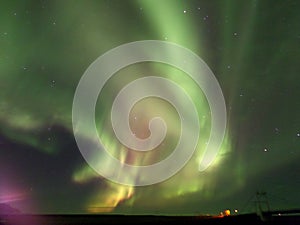 Breathtaking green and pink Aurora Borealis flashing on the night sky