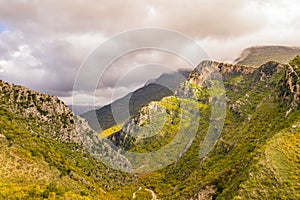 Breathtaking landscape featuring majestic green mountains and vibrant clouds in the sky above