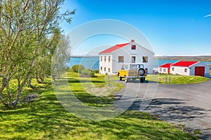 Breathtaking landscape of sunny day at Lake Myvatn with green meadow and nice house near Reykjahlid town