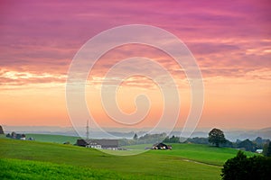 Breathtaking lansdcape of Austrian countryside on sunset. Dramatic sky over idyllic green fields of Anstrian Central Alps on autum