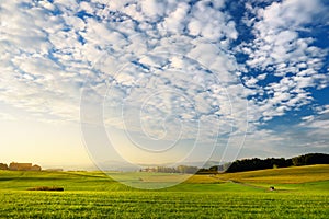 Breathtaking lansdcape of Austrian countryside on sunset. Dramatic sky over idyllic green fields of Anstrian Central Alps on autum