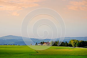 Breathtaking lansdcape of Austrian countryside on sunset. Dramatic sky over idyllic green fields of Anstrian Central Alps on autum