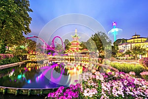 Breathtaking magical landscape in Tivoli Gardens in the evening with lake and flowers. Copenhagen, Denmark. Exotic amazing places photo