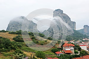 Breathtaking Meteora rocks in clouds and view to city of Kalabaka, Greece
