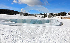 breathtaking panorama with small frozen mountain lake in winter with snow