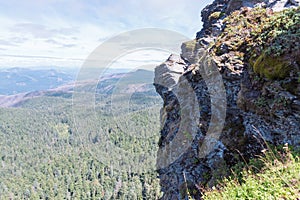 Breathtaking scenery of an enormous rock standing in the middle of a mountainous scenery