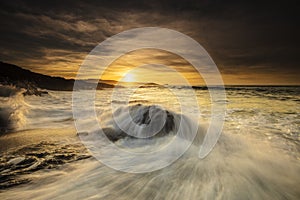 Breathtaking sunset over the fizzy ocean in Newquay, Cornwall, UK