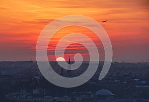 Breathtaking sunset over Lviv city, Ukraine. The aircraft takeoff over the horizon