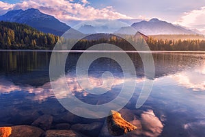 Úchvatný výhled na alpské jezero při východu slunce, mlhavá letní krajina, turistické středisko jezero štrbské pleso, vysoké tatry, slovensko