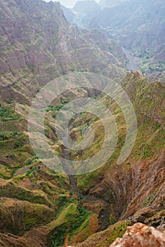 Breathtaking view of canyon with steep cliff and winding riverbed with lush green vegetation on Delgadinho mountain