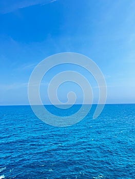 Breathtaking view of clear blue sky and calm ocean merging into the horizon