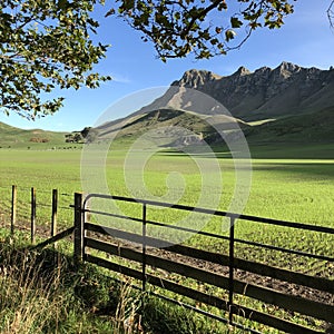 Breathtaking view of a grass-covered field by the mountains captured in Hawke's Bay, New Zealand