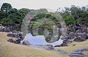 Breathtaking view on japanese garden in autumn. Beautiful maple trees around the pool with big stones