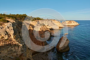 Breathtaking view of the limestone rocks with arches and small secluded beach. Algarve, Portugal