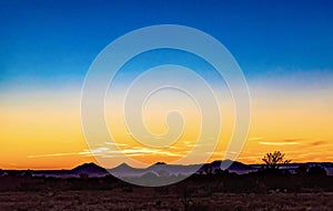 Breathtaking view of an orange and blue sunset sky over a field in Santa Fe, New Mexico