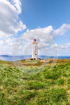 Breathtaking view of Skarsviti lighthouse in Vatnsnes peninsula on a clear day in North Iceland