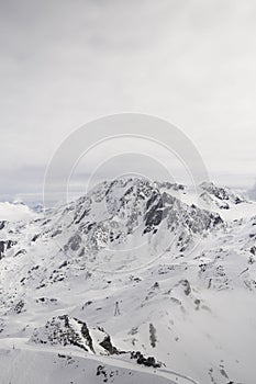 Breathtaking view of a snowy mountain in Val Thorens in the French Alps, on a cloudy day