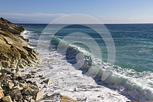 Breathtaking view of splashing sea waves under the sunlight in Varazze, Italy