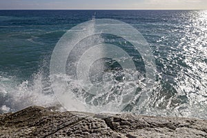 Breathtaking view of splashing sea waves under the sunlight in Varazze, Italy