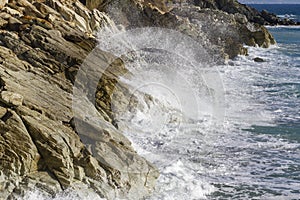 Breathtaking view of splashing sea waves under the sunlight in Varazze, Italy