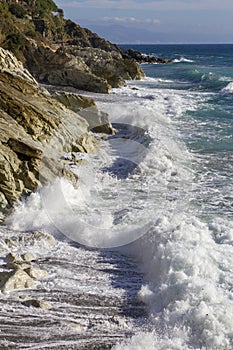 Breathtaking view of splashing sea waves under the sunlight in Varazze, Italy