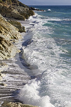 Breathtaking view of splashing sea waves under the sunlight in Varazze, Italy