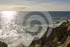 Breathtaking view of splashing sea waves under the sunlight in Varazze, Italy