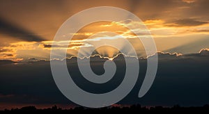 Dramatic Sunset Sky with Sun Rays Bursting Through Dark Clouds light